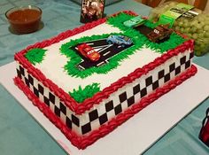 a birthday cake with cars on it sitting on a table