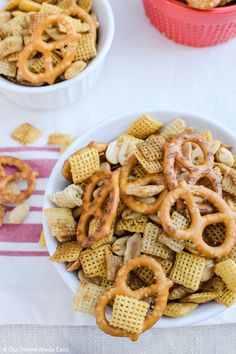 two bowls filled with cheetos and pretzels