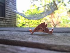 a piece of wood sitting on top of a wooden table next to a hammock