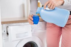 a woman is pouring water into a washing machine