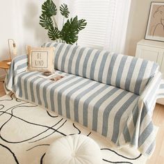 a striped couch sitting on top of a wooden floor next to a white and black rug