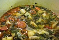 a pot filled with vegetables and sauce on top of a stove