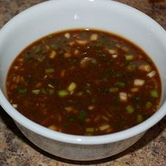 a white bowl filled with soup sitting on top of a counter