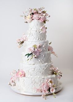 a white wedding cake with pink flowers on top