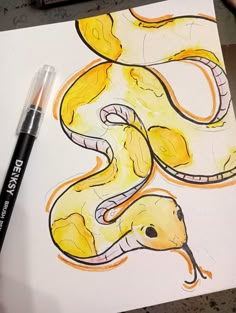 a drawing of a yellow and black snake on white paper with marker next to it