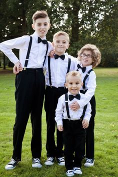 a group of young boys standing next to each other on top of a lush green field