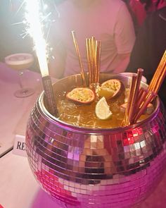 a disco ball bowl filled with sticks and fruit