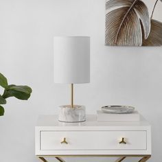 a white and gold table with a lamp on it