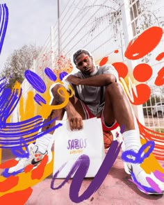 a man sitting on top of a white bag next to a basketball court with graffiti all over it