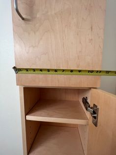 a wooden cabinet with a measuring tape on it