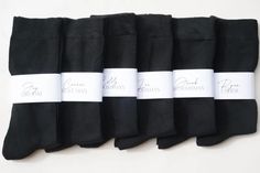 six pairs of black socks with white labels on them