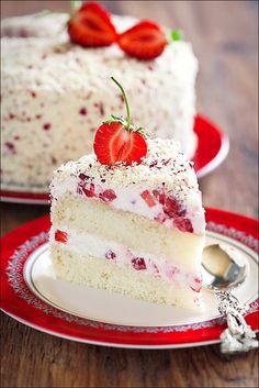 a slice of cake with strawberries on top is sitting on a red and white plate