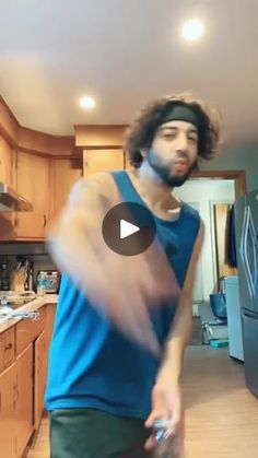 a man standing in a kitchen next to a refrigerator