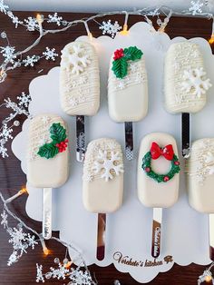 there are six ice cream pops decorated with holly wreaths and bows on the forks