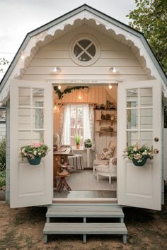 the inside of a small white shed with potted plants on it's windows