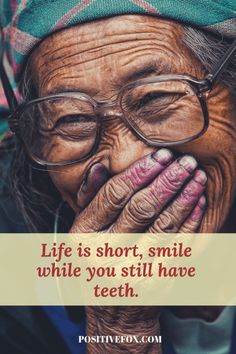 an old woman with glasses covering her mouth and holding her hands to her face, saying life is short, smile while you still have teeth