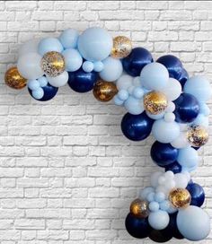 blue and gold balloon garland on a brick wall