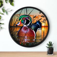 a clock with a painting of a duck on it's face next to a potted plant