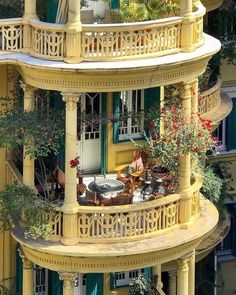 an apartment building with balconies on the balcony and patio area in front of it