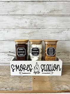 three jars filled with different types of food sitting on top of a wooden table next to each other