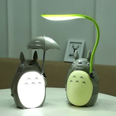 two small toy animals sitting on top of a table next to an umbrella and lamp