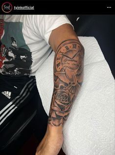 a man with a clock and roses tattoo on his arm is sitting in front of a bed