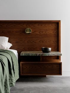 a bed with a wooden headboard next to a night stand