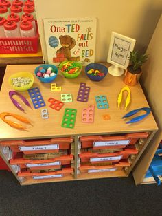 a child's table with toys and books on it in a playroom area