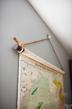 an old map hanging on the wall with a rope attached to it's side