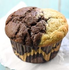 a chocolate chip muffin sitting on top of a piece of paper