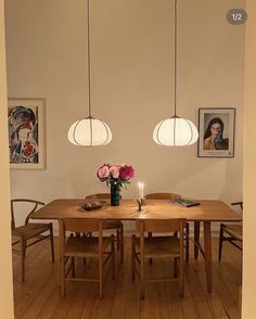 a dining room table and chairs with flowers in vases on the table next to it