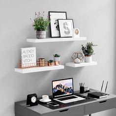 a desk with two shelves above it and a laptop computer on the table next to it