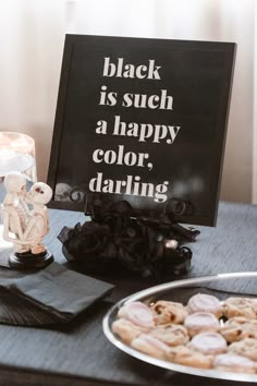 black is such a happy color, daring sign next to donuts on a table