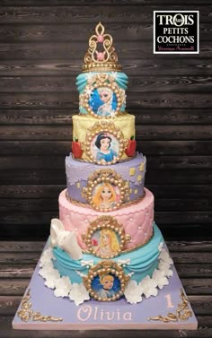 there is a multi layer cake with princesses on it