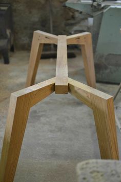 two wooden stools sitting next to each other on top of a cement floor in a room