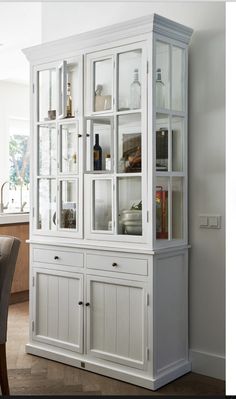 a white china cabinet with glass doors in a living room or dinning room area