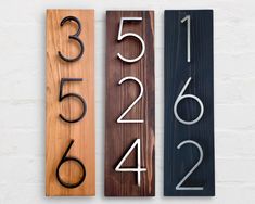 three wooden signs with numbers on them sitting next to each other