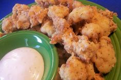 a green plate topped with tater tots and ranch dressing