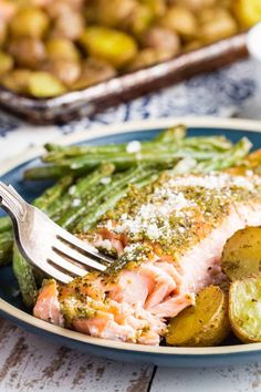 a plate with salmon, potatoes and green beans