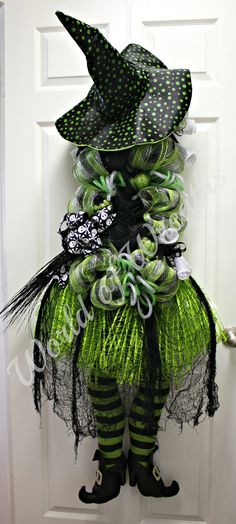 a green and black costume is hanging on the door