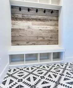 a white bench sitting in the middle of a room with black and white flooring