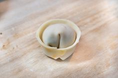 an uncooked dumpling sitting on top of a wooden cutting board