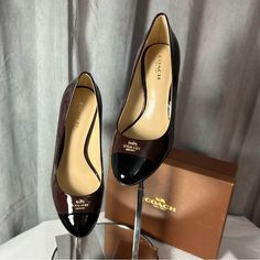 Absolutely Gorgeous Pair Of Patent Leather Coach Pumps In Dark Brown And Black With Gold-Toned Coach Logo Pinned At Toe. These Pumps Are Perfect In Every Way! Flawless And New With Original Box! Perfect For Work And Any Formal Setting. Brought To You By Bev @Bevsboutiques Brown Flat Heel Heels For Business, Brown Flat Heels For Business, Brown Patent Leather Heels With Low Heel, Brown Patent Leather Heels For Work, Brown Almond Toe Heels For Business Casual, Coach Black Heels For Work, Coach Brown Heels With Branded Insole, Coach Brown Pointed Toe Heels, Coach Brown Almond Toe Heels