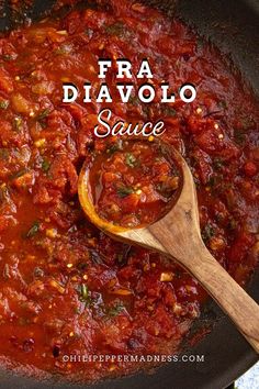 a skillet with sauce and a wooden spoon in it that says fra diavolo sauce