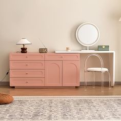 a pink dresser and chair in a room with a rug on the floor next to it