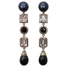 Black pearls mark the tops and the bottoms of these dramatic dangle earrings. The round button and drop shaped pearls are blemish free and have beautiful luster. Mounted between are radiant cut and classic emerald cut platinum topaz and brilliant cut black spinel. All the gems are well cut, well polished and very lively. The handmade yellow gold settings have posts and come with jumbo friction backs. Bling Earrings, Black Pearls, Round Button, Yellow Gold Setting, Black Spinel, Earrings Dangle, Black Pearl, White Topaz, Pearl White