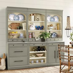 a gray china cabinet with plates and bowls on it