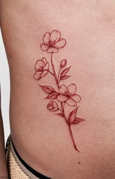 a close up of a person's stomach with flowers tattooed on the side,