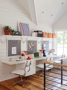 a home office with white walls and wood flooring, along with two computer desks