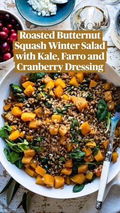 roasted butternut salad with spinach, farro and cranberries in a white bowl